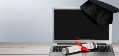 Laptop with diploma and graduation cap 