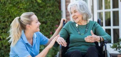 Elderly woman in wheelchair at home with home health worker