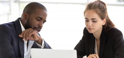 Manager and employee discussing career path and looking at laptop