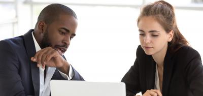 Manager and employee discussing career path and looking at laptop