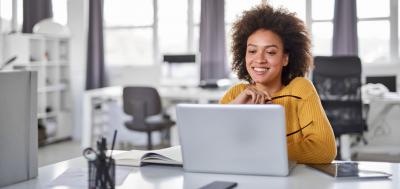 Female content strategist looking at laptop in office