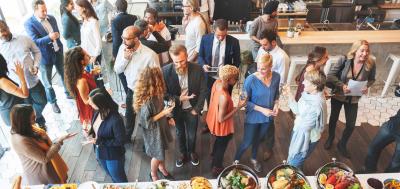 Crowd of Champlain College Online alumni mingling in cafe at event