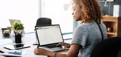 Professional woman doing work on laptop in office setting