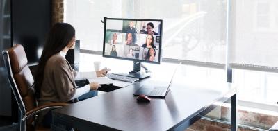 Business woman meeting with colleagues virtually on computer.