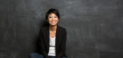 Student sitting on floor in front of chalkboard