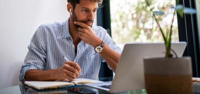 Adult male software development student focused and working on laptop