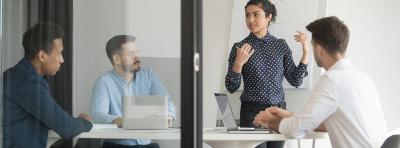 woman leading a meeting with men sitting at a table