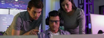 two men and one woman around two monitors 