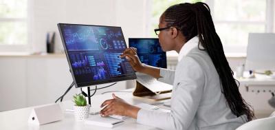 african american woman with long hair at a monitor with data on it