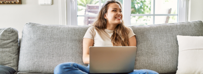 young woman sitting on couch with laptop