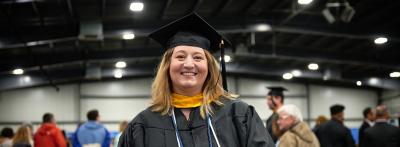 Female graduate dressed in graduation regalia smiling portrait