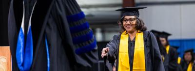 Female graduate walking across stage during commencement ceremony