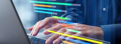 Person typing on a laptop with a colorful Gantt chart project timeline overlay