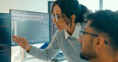 Two IT professionals looking at a computer screen.