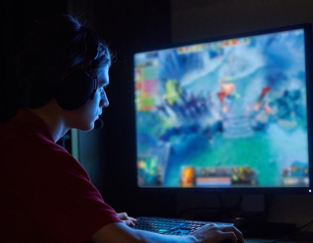 Boy planing a video game on desktop computer