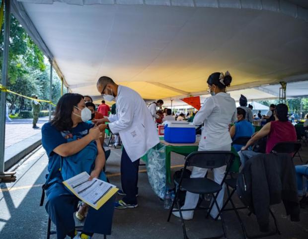 Doctors administering shots to patients in a medical tent