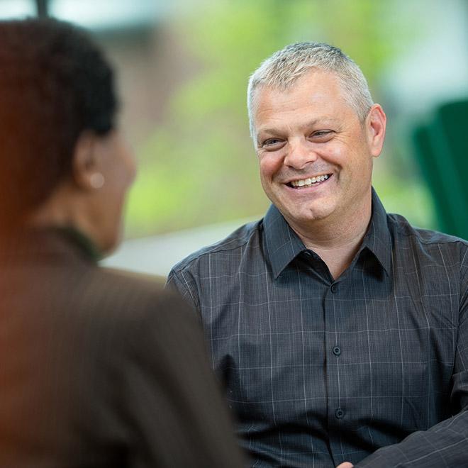 Online leadership graduate certificate student having a friendly discussion with a colleague