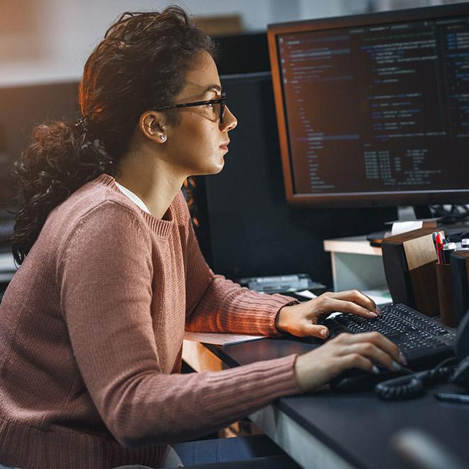 Woman on a computer in computer lab looking at code