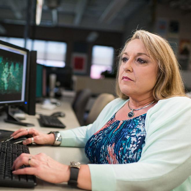 Online cybersecurity student on a computer in a computer lab