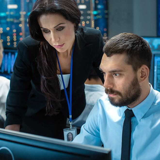 Man and woman looking at a computer in a control room