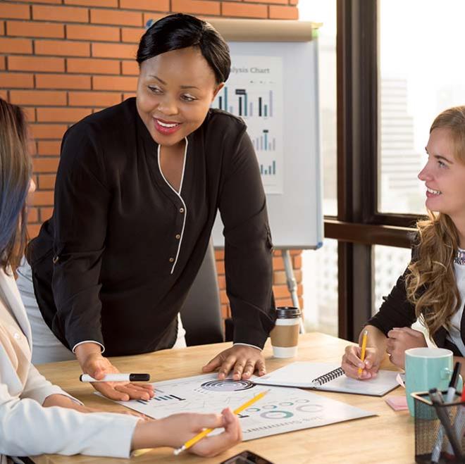 women around a table discussing plans