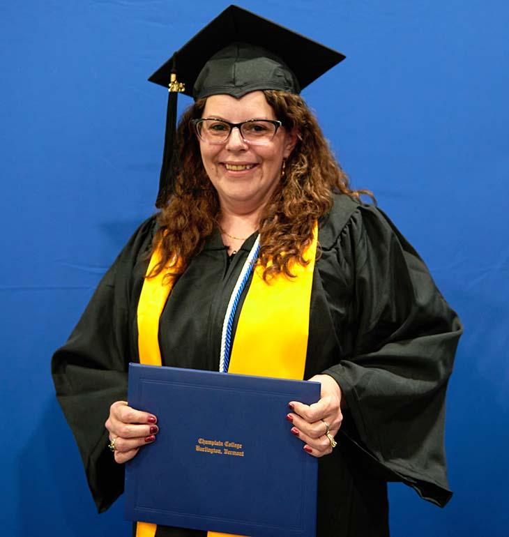 CCO graduate Alina in cap and gown holding diploma