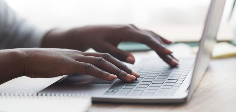 Photo of hands typing on a laptop